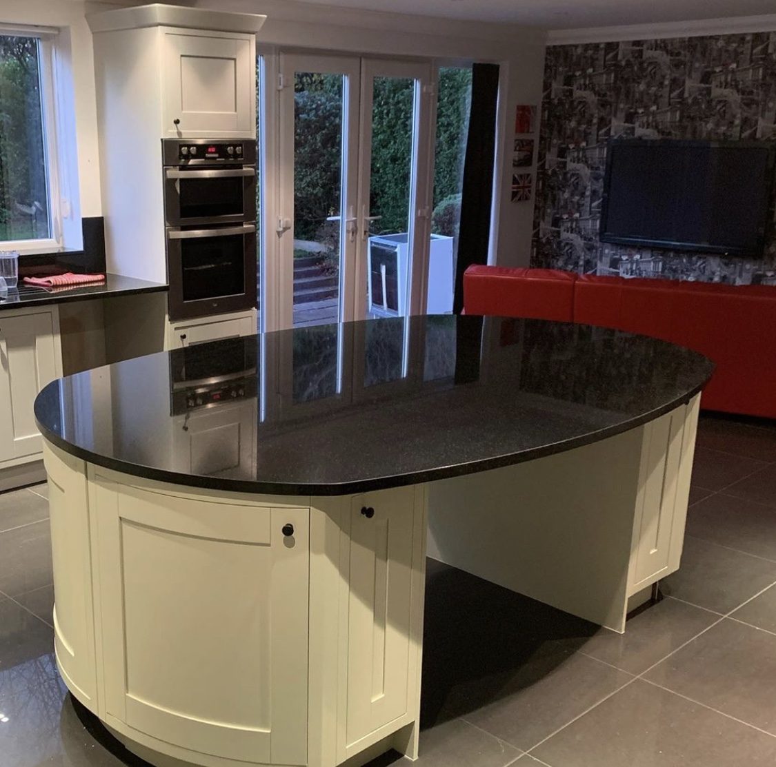 A cream shaker kitchen with a curved island, freshly sprayed