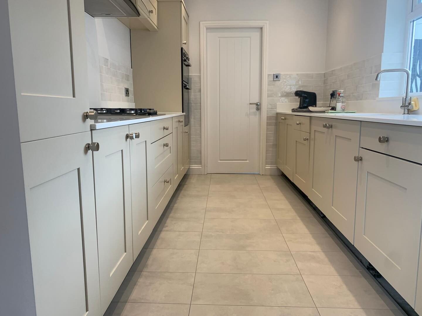 A galley kitchen sprayed a soft stone colour